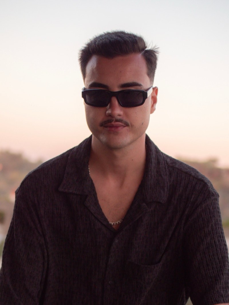 Retrato de Crazypapi ao pôr do sol, de óculos escuros e camisa preta